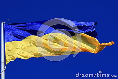 Beautiful flag of Ukraine in sky. Large Ukrainian flag flutters, the concept of struggle of Ukraine people against war of Russia. Stock Photo