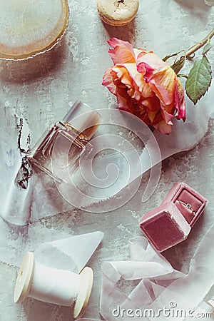 Beautiful flat barking in gently pink colors: perfume, box with ring, rose, satin ribbon, macaroon Stock Photo