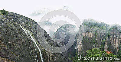 Beautiful foggy mountain view with waterfall and pagoda Stock Photo