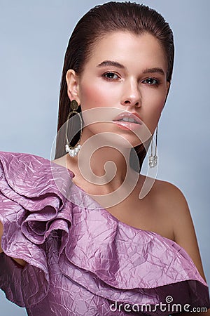 Beautiful fresh girl with classic make-up, smooth hair in a purple dress. Beauty face. Stock Photo