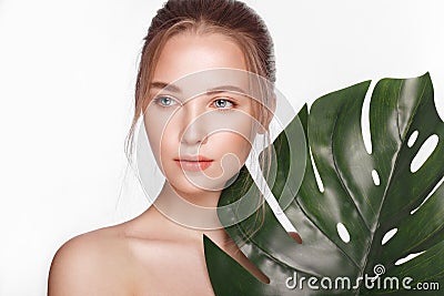 Beautiful fresh girl with perfect skin, natural make up and green leaves. Beauty face. Stock Photo