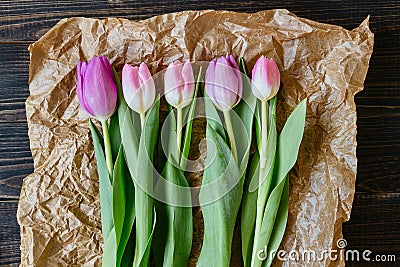 Beautiful fresh tulips with paper on the wooden background Stock Photo
