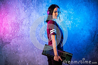 Beautiful Friendly Pro Gamer Streamer Girl Posing With a Keyboard in Her Hands, Wearing Glasses. Attractive Geek Girl Stock Photo