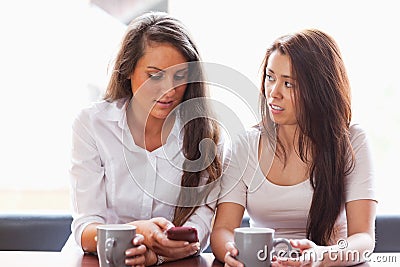 Beautiful friends looking at a smartphone Stock Photo