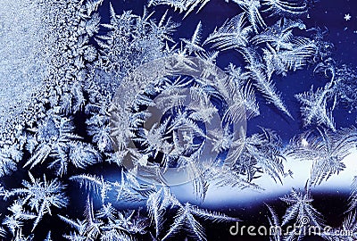 frosty pattern with various ornate patterns on transparent glass on winter window Stock Photo