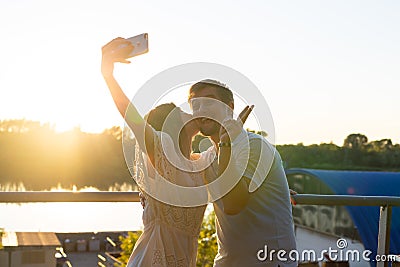 Beautiful funny romantic couple on nature background. Attractive young woman and handsome man are making selfie, smiling Stock Photo
