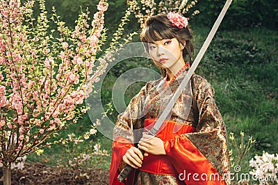 Beautiful geisha in kimono with samurai sword Stock Photo