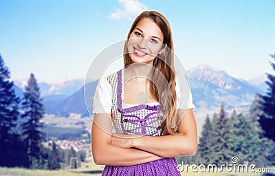 Beautiful german woman in bavarian dirndl with rural landscape Stock Photo