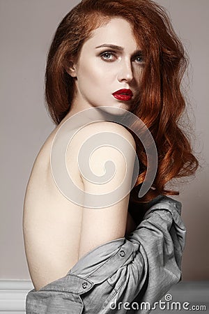 Beautiful ginger young woman with luxury hair style and fashion gloss makeup. Beauty closeup model with red hair Stock Photo