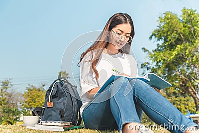 Beautiful girl in autumn forest reading a book covered with a warm blanket.a woman sits near a tree in an summer forest and holds Stock Photo