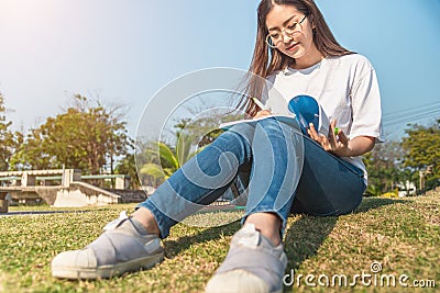 Beautiful girl in autumn forest reading a book covered with a warm blanket.a woman sits near a tree in an summer forest and holds Stock Photo