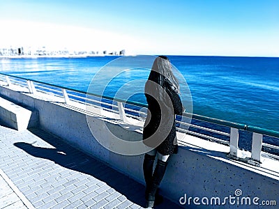 Beautiful girlin black dress staring at the beach. Fantasy world concept Stock Photo