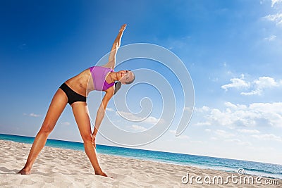Beautiful girl bending body with arm up on beach Stock Photo
