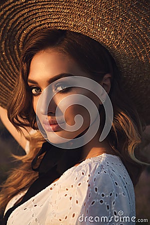 Beautiful girl with blond hair in elegant clothes posing in summer flowering lavender field Stock Photo