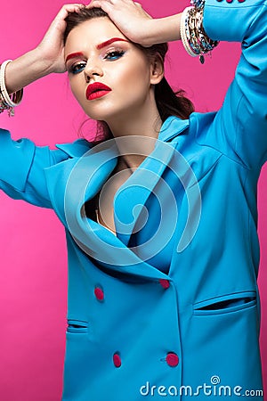 Beautiful girl in blue suit on pink background with creative make-up and fashionable style. Beauty face. Stock Photo