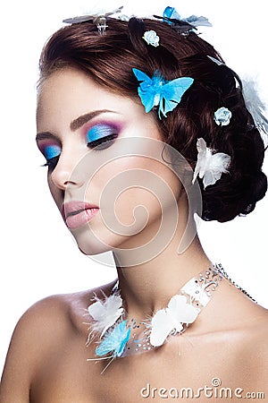 Beautiful girl with bright blue makeup and butterflies in her hair. Stock Photo