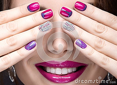 Beautiful girl with a bright evening make-up and pink manicure with rhinestones. Nail design. Beauty face. Stock Photo