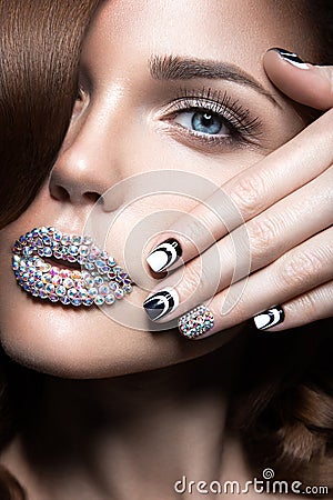 Beautiful girl with bright nails and lips of crystals, long eyelashes and curls. Beauty face. Stock Photo