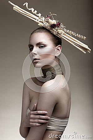 Beautiful girl with a bronze skin, pale makeup and unusual accessories. Art beauty image. Beauty face. Stock Photo