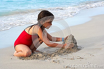 Beautiful girl building a sand castle in the beach Stock Photo