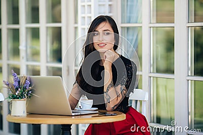 Beautiful girl businesswoman working on laptop in cafe, female freelancer Stock Photo