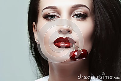 Beautiful girl with cherries in her mouth Stock Photo