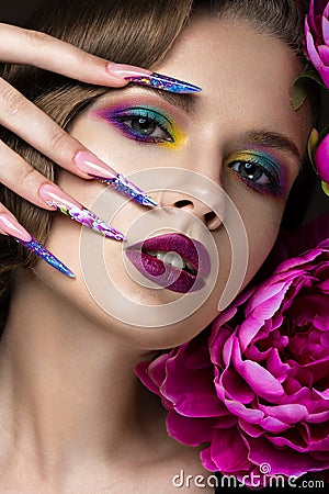 Beautiful girl with colorful make-up, flowers, retro hairstyle and long nails. Manicure design. The beauty of the face. Stock Photo