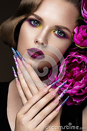 Beautiful girl with colorful make-up, flowers, retro hairstyle and long nails. Manicure design. The beauty of the face. Stock Photo