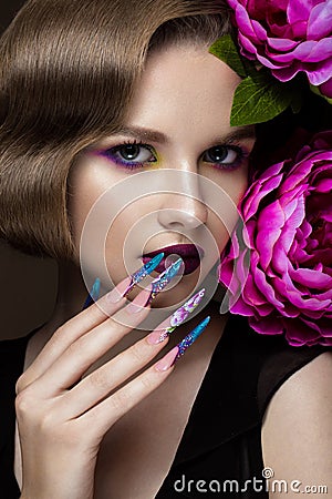 Beautiful girl with colorful make-up, flowers, retro hairstyle and long nails. Manicure design. The beauty of the face. Stock Photo