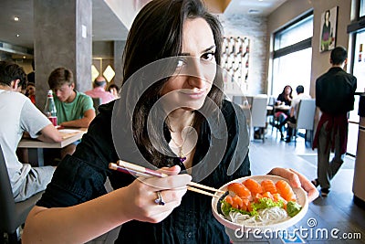 Beautiful girl with dark hair, dressed in black is holding a plate full of sushi Stock Photo