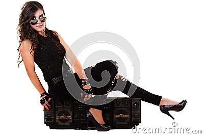 Beautiful girl in dark leather clothes holding a large retro radio Stock Photo