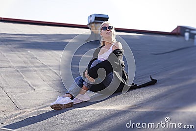 Beautiful girl decided to relax on the roof of the house. Stock Photo