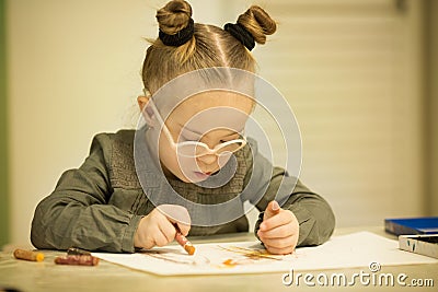 Beautiful girl with a Down syndrome draws with pencils Stock Photo
