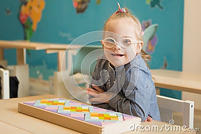 Beautiful girl with down syndrome engaged in class Stock Photo