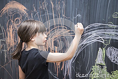 Beautiful girl drawing on a blackboard Stock Photo