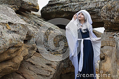 Beautiful girl dressed as an elf in a white dress. Posing on the stones Editorial Stock Photo