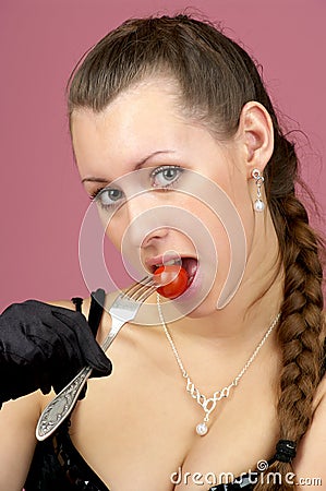 Beautiful girl eating small tomato Stock Photo