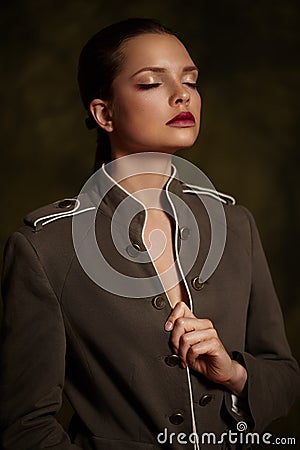 Beautiful girl in fashionable coat on dark background. Stock Photo
