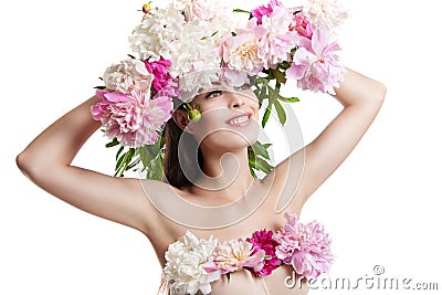 Beautiful girl with flowers peonies. Portrait of a young woman with flowers in her hair and a dress of flowers. Stock Photo