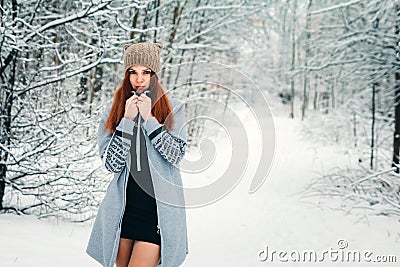 Beautiful girl freezes in the winter in the forest. Photo in cold tones Stock Photo