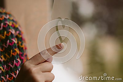 Beautiful girl hand drawing hearts in the window. Love concept. Stock Photo