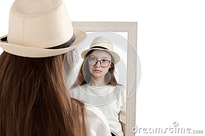 Beautiful girl in hat looks in mirror, Studio portrait on white background Stock Photo