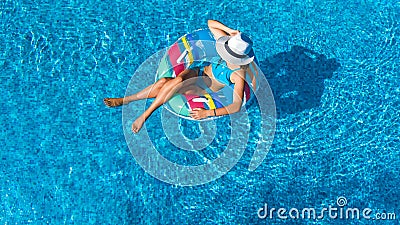 Beautiful girl in hat in swimming pool aerial top view from above, woman relaxes and swims on inflatable ring donut and has fun Stock Photo