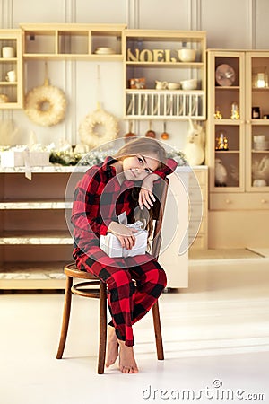 Beautiful girl holding Xmas present in the bright New Year interior. Family, tradition, celebration Stock Photo