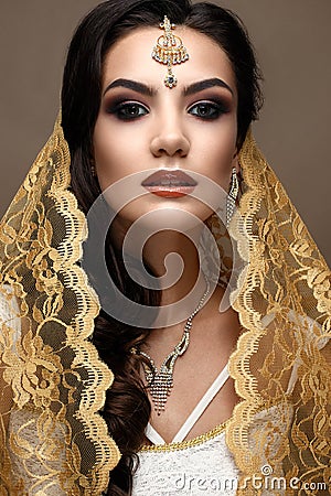 Beautiful girl in Indian style with a scarf on her head. Model with a creative and bright makeup Stock Photo