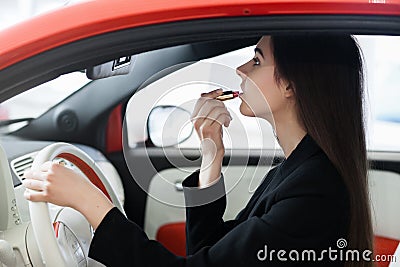 Beautiful girl inside the car doing make-up Stock Photo