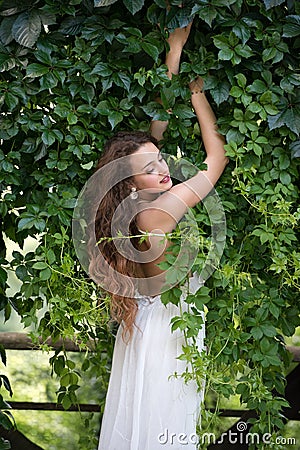 Beautiful girl leaning on a moss wall Stock Photo