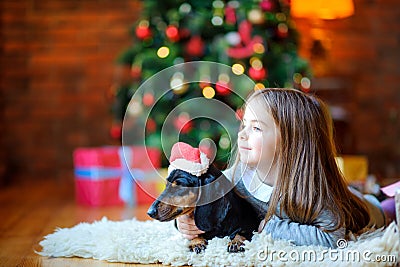 Beautiful girl lies on the carpet with a little dog Stock Photo