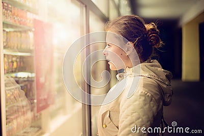 Beautiful girl looking in the shopwindow on the night. Stock Photo