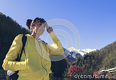 A beautiful girl looks into the distance with enthusiasm against the background of a mountain landscape Stock Photo
